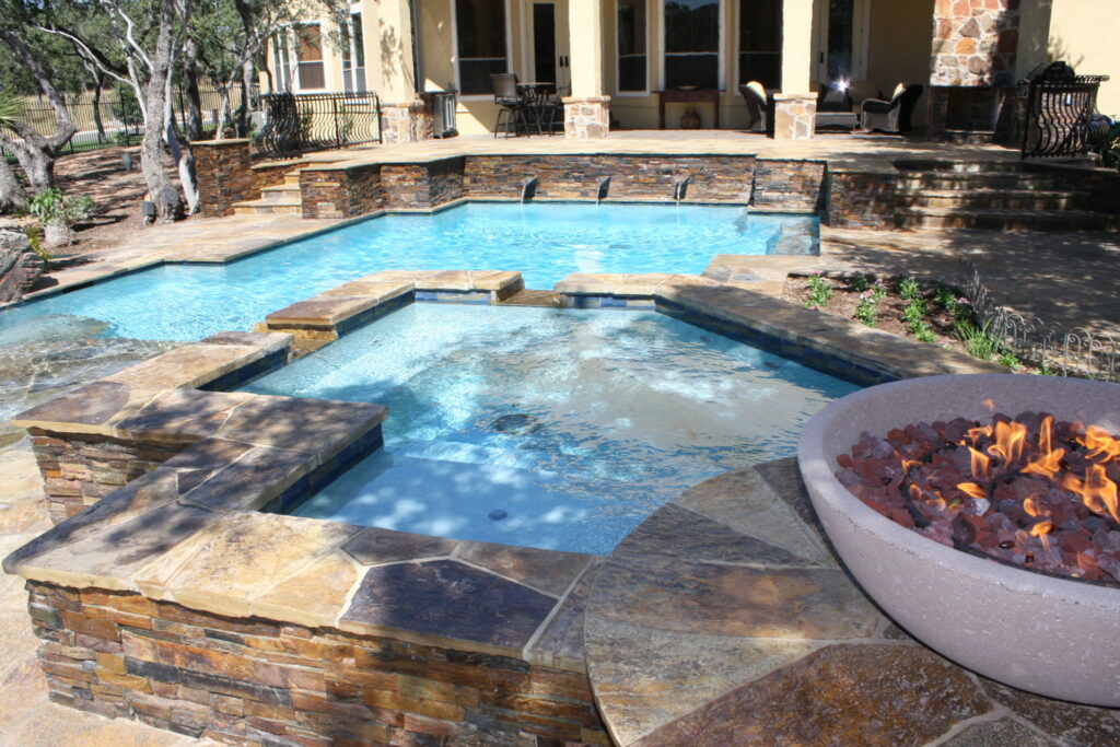 Contemporary pool with flagstone faced raised spa