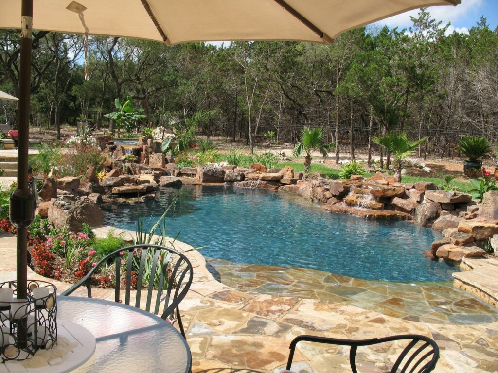 Freeform pool with moss rock waterline, raised spa and Flagstone Sun Shelf