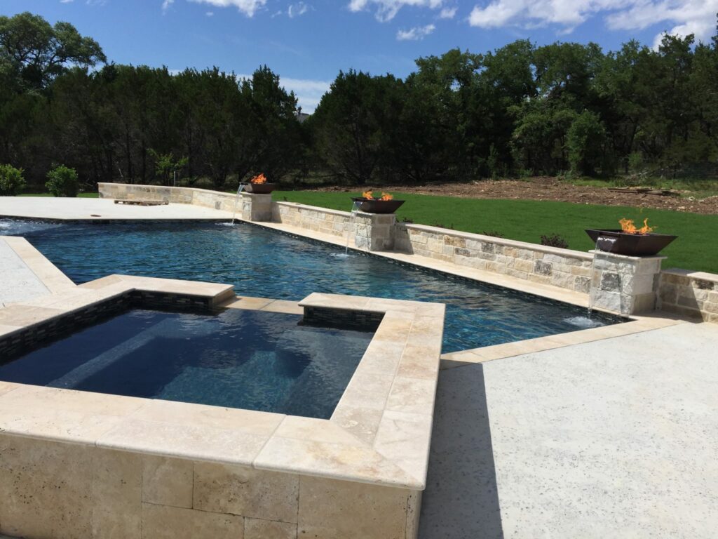 contemporary pool with fire woks and raised spa